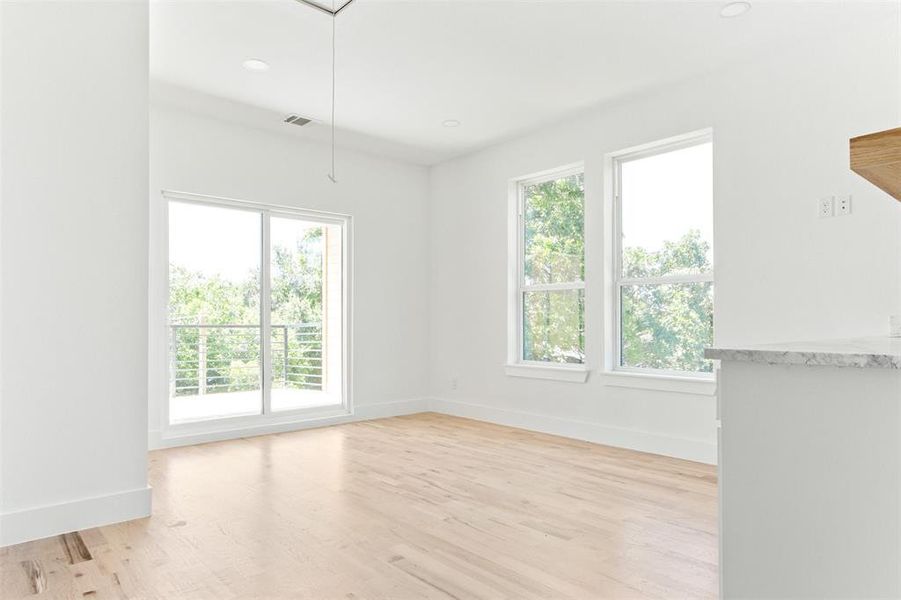 Spare room featuring a wealth of natural light and light hardwood / wood-style flooring