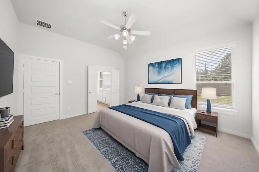 A bedroom with a bed and a fan.