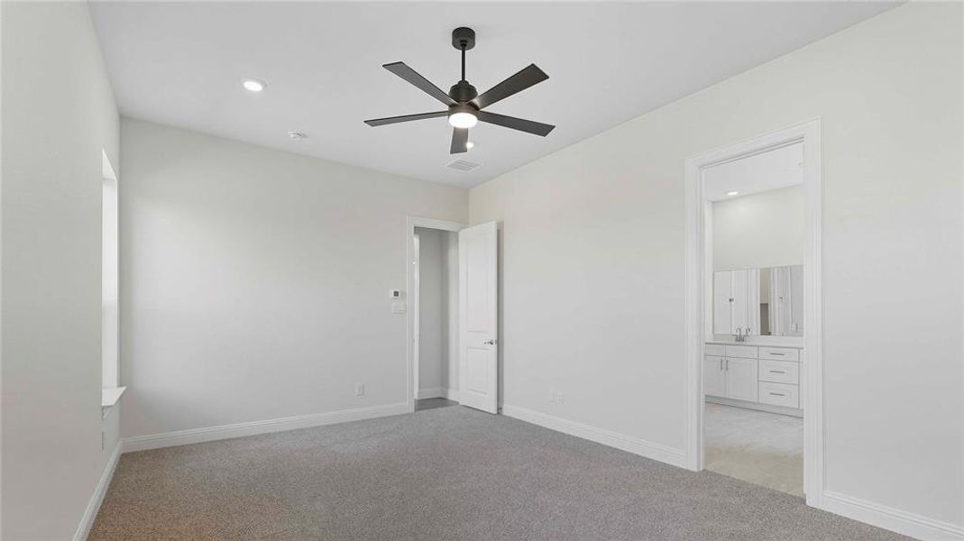 Unfurnished bedroom featuring light colored carpet, recessed lighting, connected bathroom, and a ceiling fan