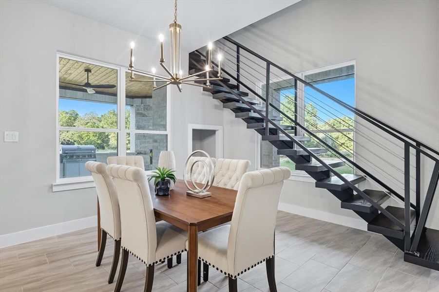 Dining space with plenty of natural light, a chandelier, and stairs Dining space with plenty of natural light, a chandelier, and stairs