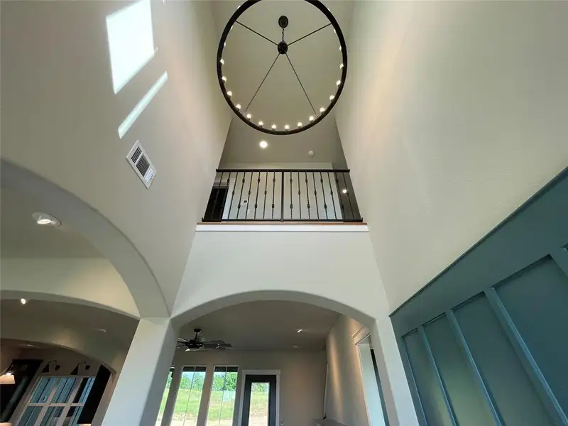 Soaring ceilings with a large contemporary chandelier and recessed lighting