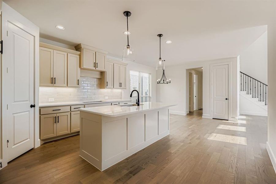Kitchen featuring decorative backsplash, hanging light fixtures, light stone countertops, recessed lighting, and an island with sink Kitchen featuring decorative backsplash, hanging light fixtures, light stone countertops, recessed lighting, and an island with sink