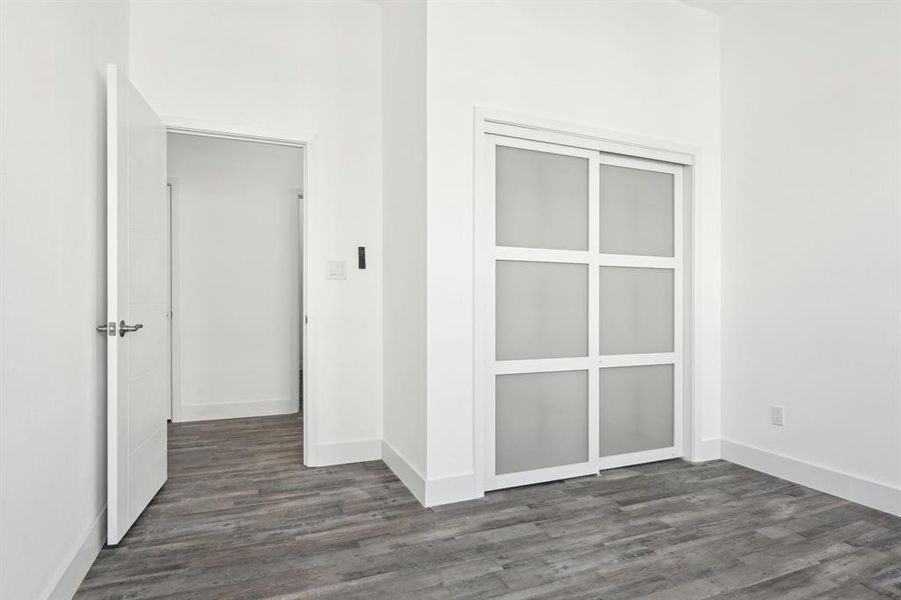 Unfurnished room featuring baseboards and dark wood-type flooring