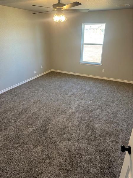 Carpeted spare room featuring ceiling fan