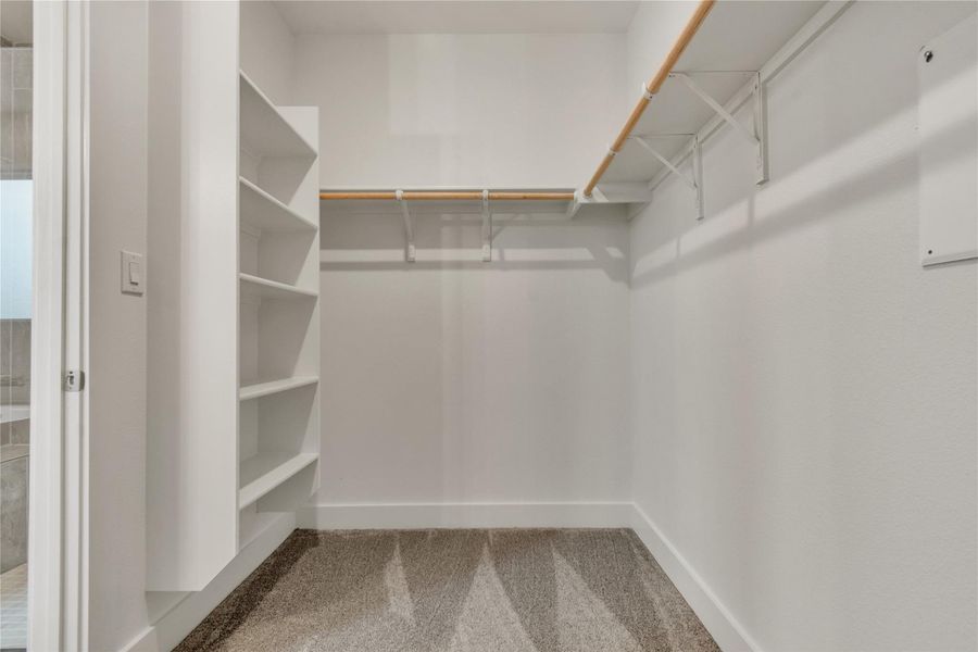 An organized closet featuring built-in shelving and ample hanging space for streamlined storage.