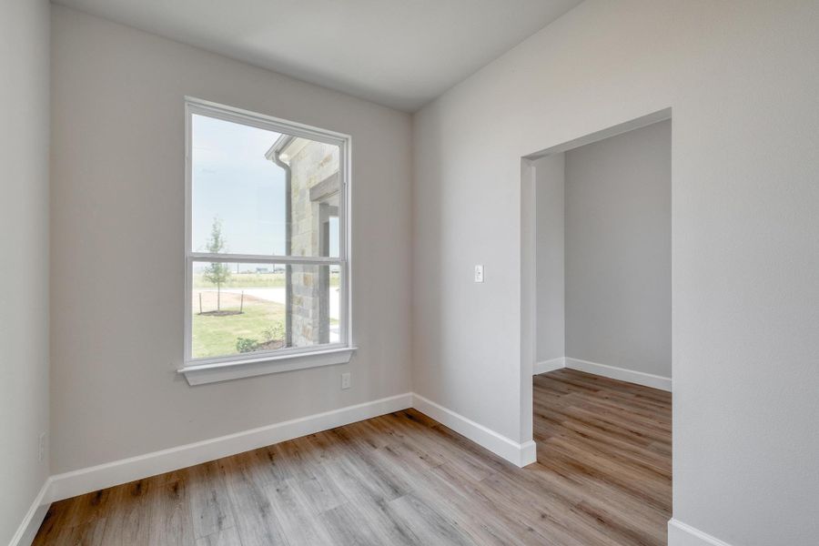 Unfurnished room with light wood finished floors and baseboards