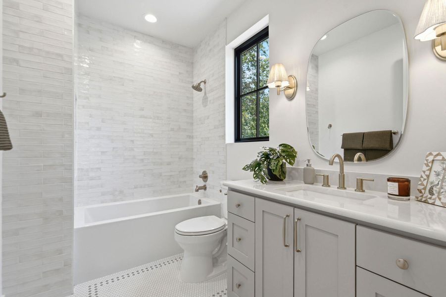 Gleaming tile work and elegant fixtures define this modern bathroom with its clean design.