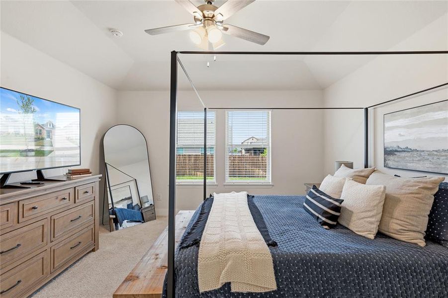 Spacious room featuring a vaulted ceiling and a ceiling fan with integrated lighting
