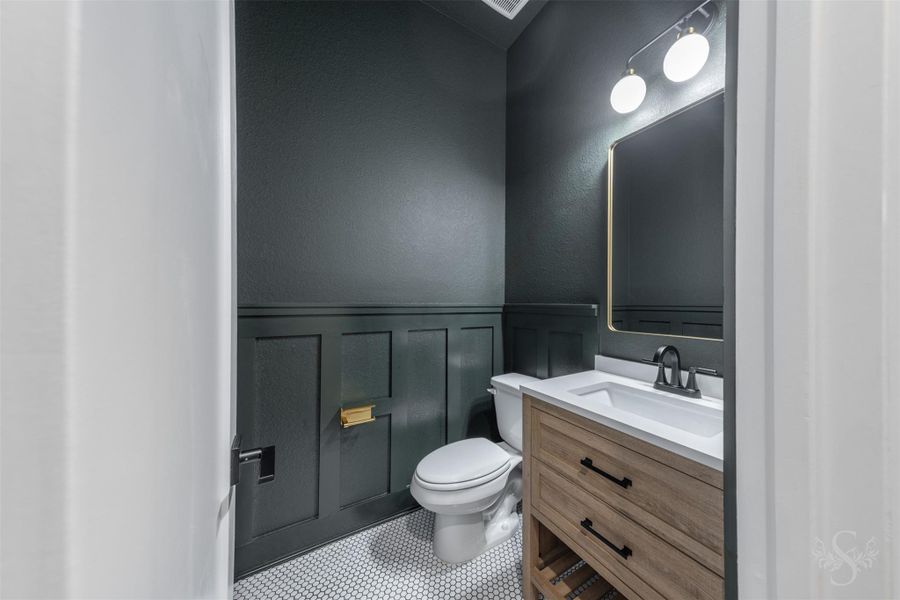 Powder room, located downstairs. Fully updated with new vanity, flooring, paint, light fixture, mirror, and wainscoting. Powder room, located downstairs. Fully updated with new vanity, flooring, paint, light fixture, mirror, and wainscoting.