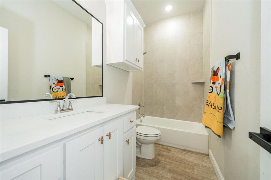 Full bath featuring vanity, shower / bath combination, light wood finished floors, and recessed lighting Full bath featuring vanity, shower / bath combination, light wood finished floors, and recessed lighting