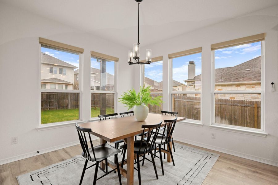 The kitchen's sunny dining area is nestled in generous corner windows and offers ample space for a sizable dining table. The kitchen's sunny dining area is nestled in generous corner windows and offers ample space for a sizable dining table.