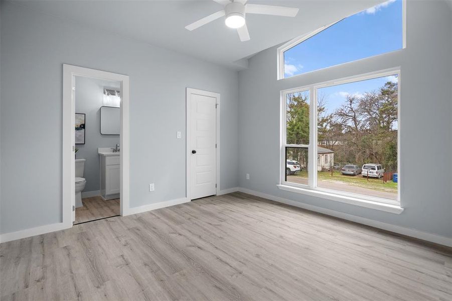 Unfurnished bedroom with light wood-type flooring, ceiling fan, and ensuite bathroom Unfurnished bedroom with light wood-type flooring, ceiling fan, and ensuite bathroom