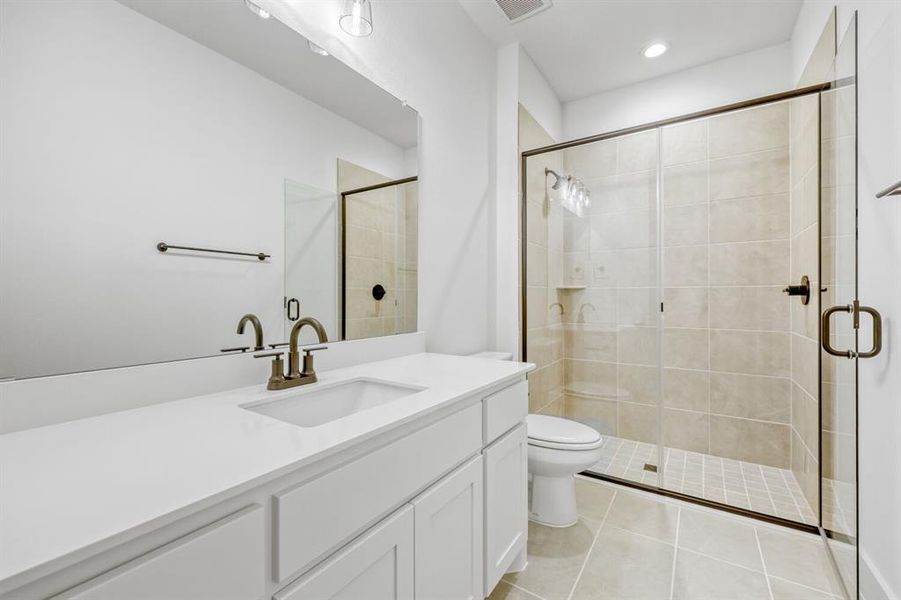 Bathroom featuring vanity, a stall shower, light tile patterned floors, and recessed lighting