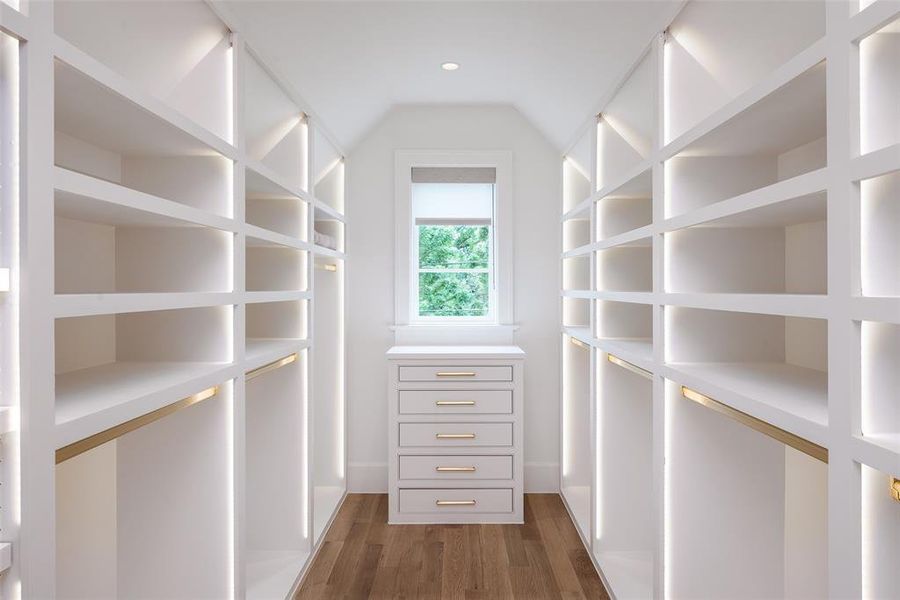 Primary boutique style closet with specialty lighting