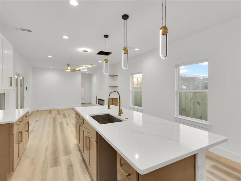 Kitchen with a large island, decorative light fixtures, and sink