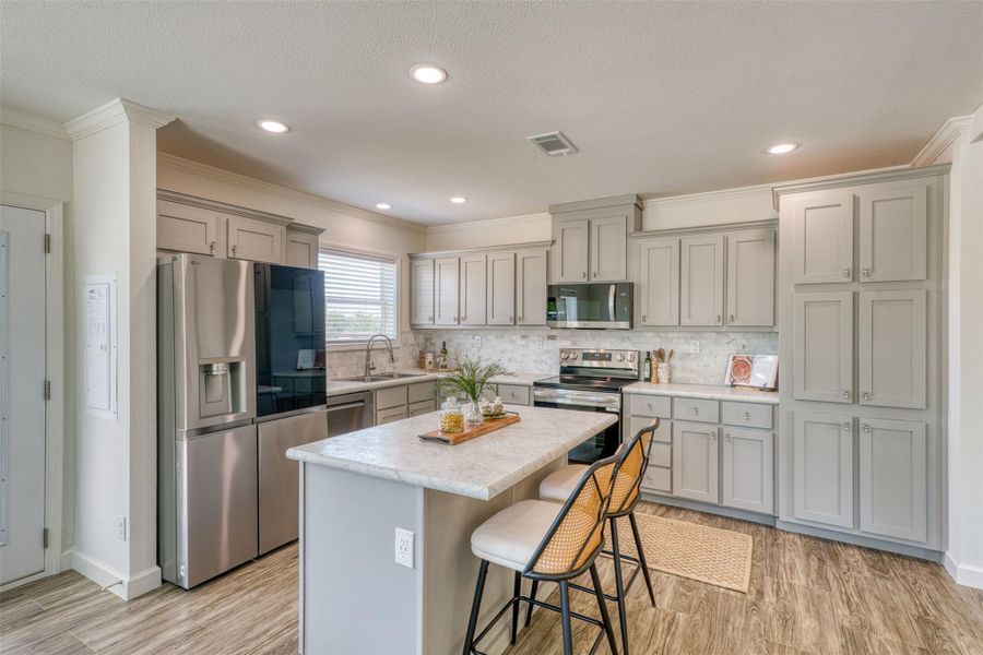 A well-appointed kitchen showcasing an island, ample cabinetry, and modern appliances for culinary ease. A well-appointed kitchen showcasing an island, ample cabinetry, and modern appliances for culinary ease.