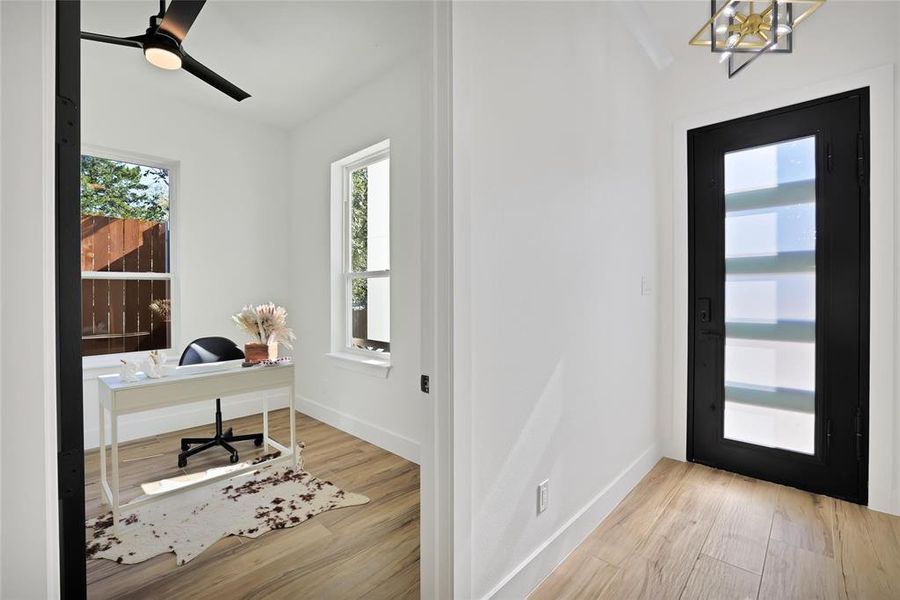 Entrance foyer featuring wood finished floors, a chandelier, and baseboards