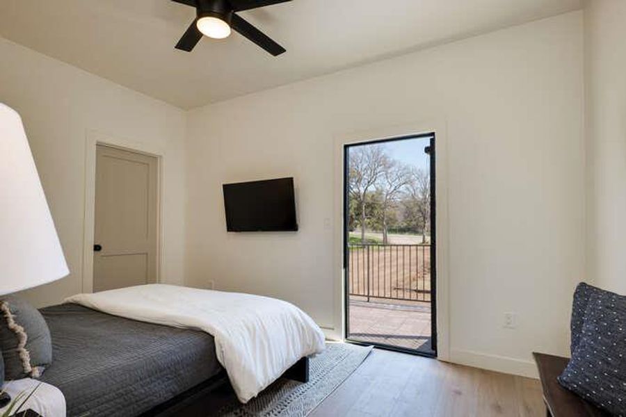 Bedroom with wood finished floors, access to outside, and ceiling fan