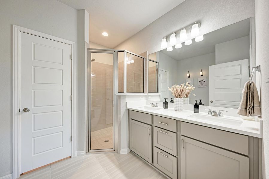 Bathroom with double vanity, a stall shower, light tile patterned flooring, and recessed lighting