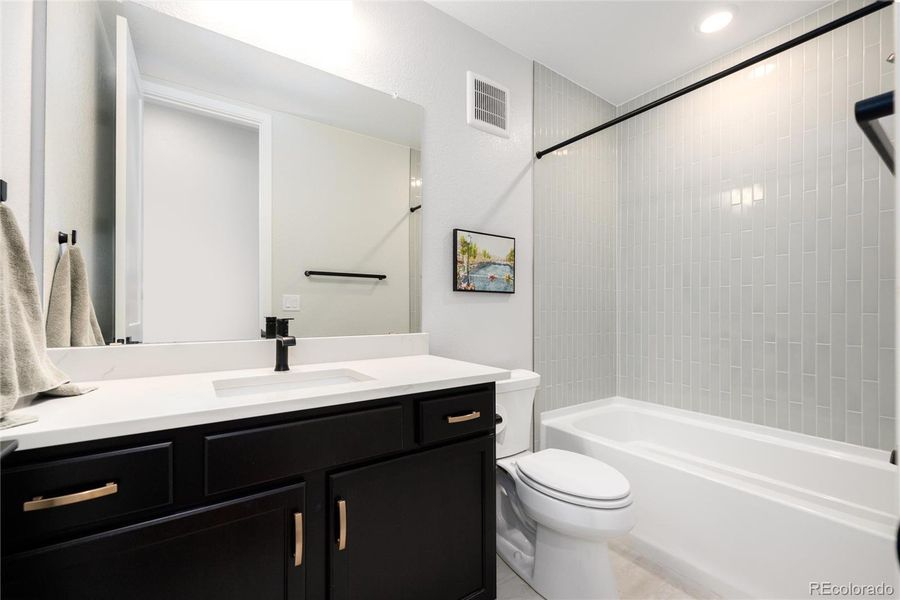 Full bath in finished basement next to downstairs bedroom.