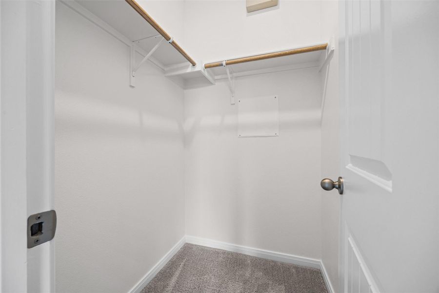 Built-in shelving and hanging rods maximize storage within this carpeted closet. Built-in shelving and hanging rods maximize storage within this carpeted closet.