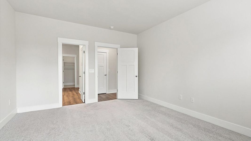 Eye-catching details and elegant finishes in the vibrant primary suite of this select home by DRB Homes