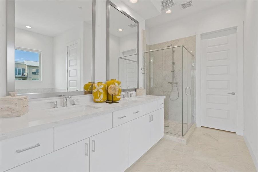 Primary bath with tall mirrors and large walk in shower with bench seat.  Similar home and finishes.