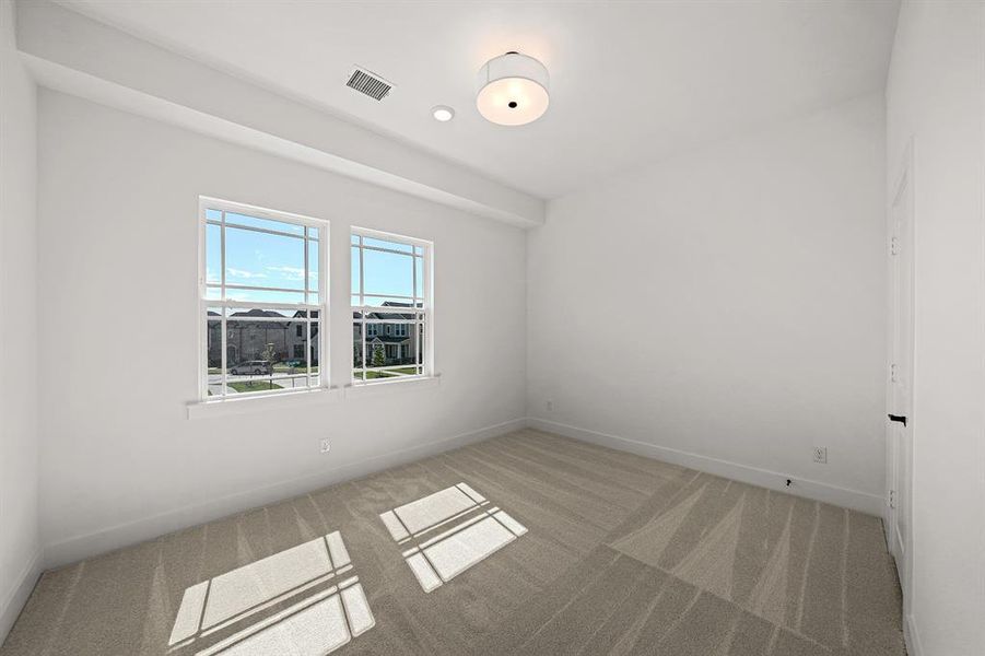 Spare room featuring light colored carpet and baseboards