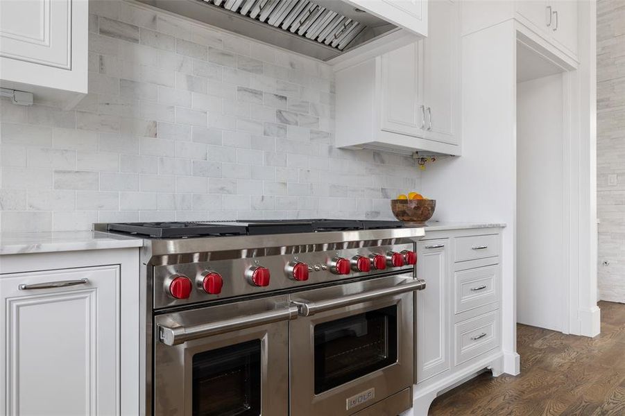 The gourmet kitchen features Energy Star Certified Wolf gourmet appliances including 24" Wolf Microwave, 24" Asko Dishwasher, and this stunning 48" 8-Burner Gas Cooktop (Griddle Optional) Image from previously completed home in the community.