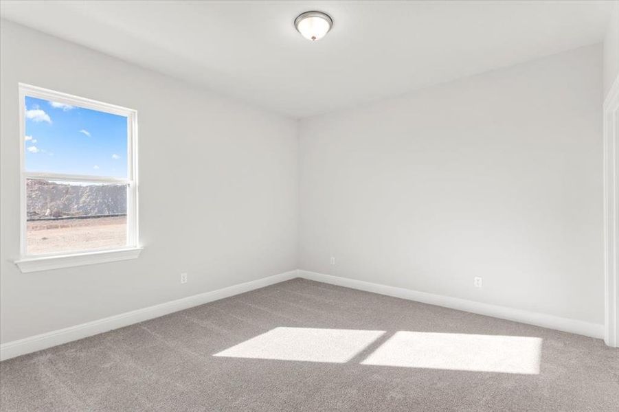 Spare room with light colored carpet and baseboards