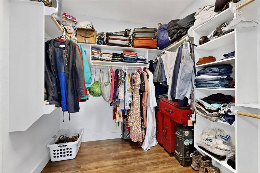 Walk in closet with dark wood finished floors