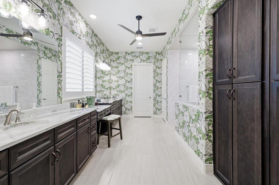 Spa-Inspired Primary En-Suite Bath with Coordinating Designer Thibaut Wallpaper, Coordinating Portinari Dolomite Countertops, Spacious Curb-less Shower, Private Water Closet, and an Oversized Walk-in Closet.