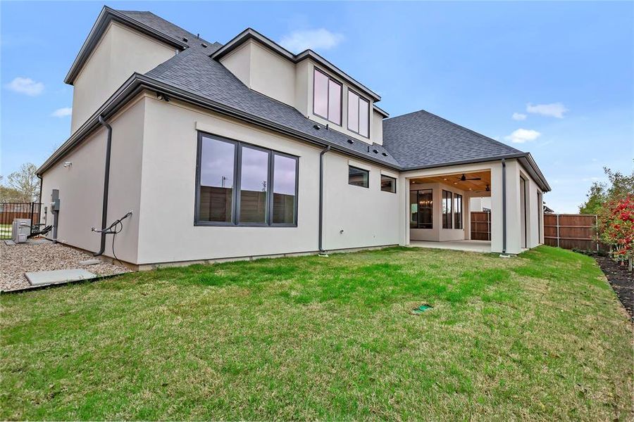 Back of house with a fenced backyard, a patio area, ceiling fan, a shingled roof, and stucco siding