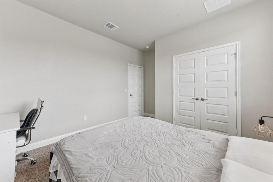 Carpeted bedroom with baseboards and a closet Carpeted bedroom with baseboards and a closet