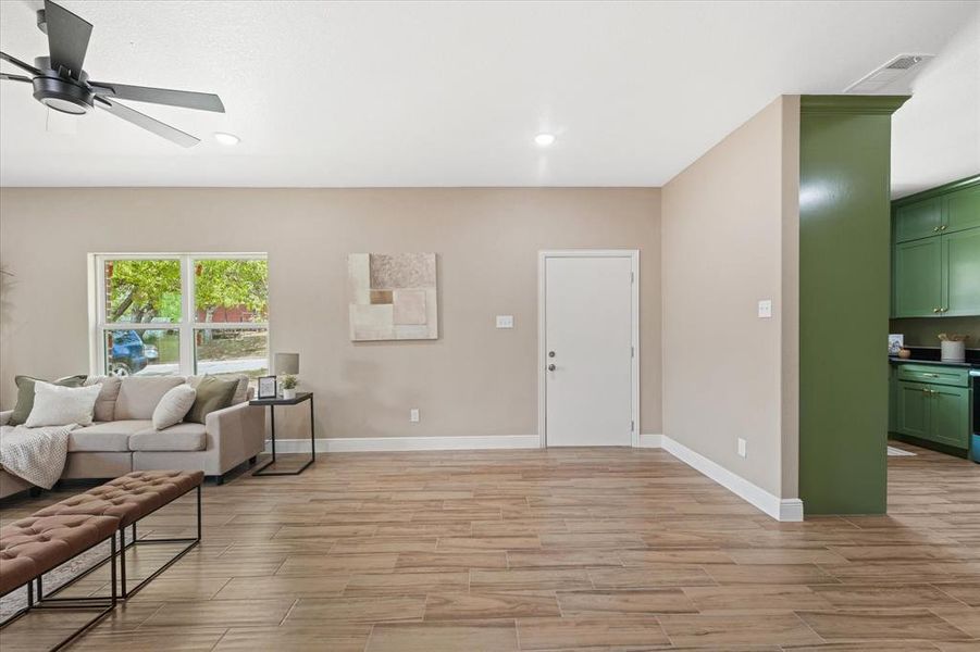 Living area featuring wood tiled floors, ceiling fan, and recessed lighting Living area featuring wood tiled floors, ceiling fan, and recessed lighting