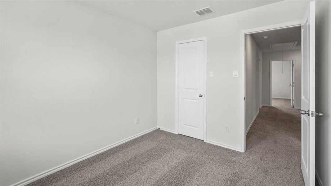 This room features light grey carpeting and white walls, offering a neutral palette