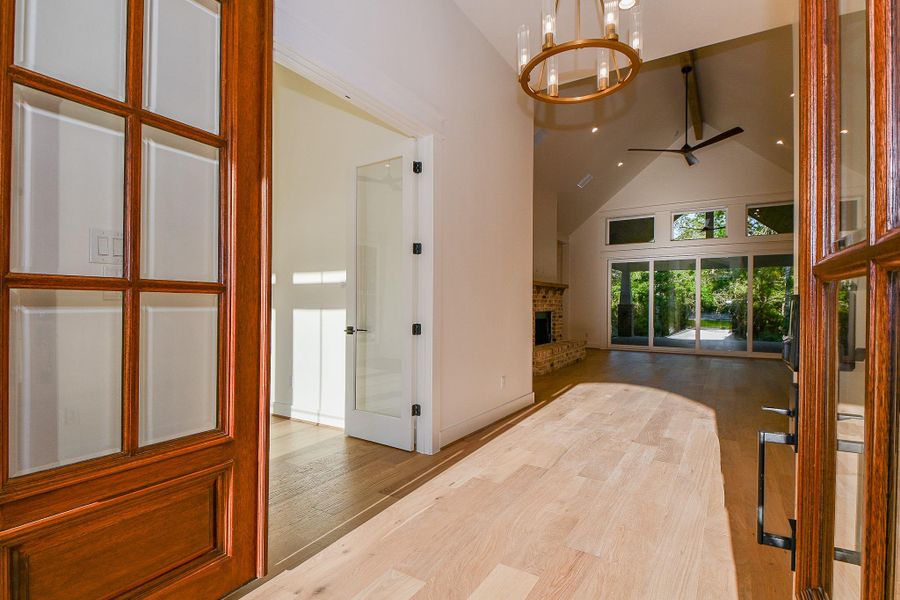 Step onto the brick porch and through the beautiful wood and glass front door into a bright, airy foyer. The dramatic vaulted ceiling, oversized chandelier, and expansive view to the back of the home immediately create a sense of grandeur and openness. Step onto the brick porch and through the beautiful wood and glass front door into a bright, airy foyer. The dramatic vaulted ceiling, oversized chandelier, and expansive view to the back of the home immediately create a sense of grandeur and openness.