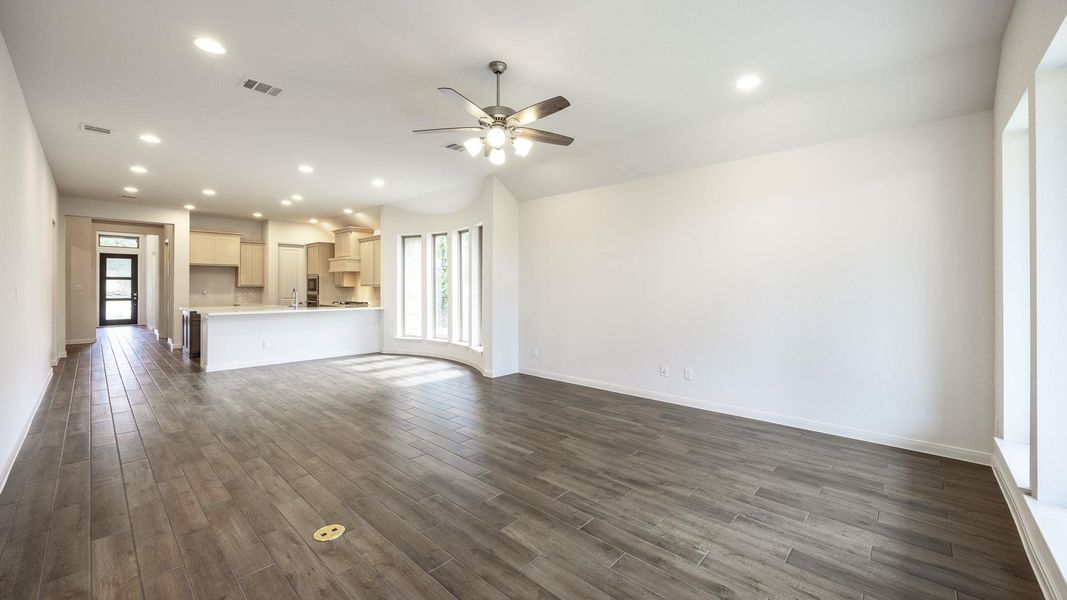 Unfurnished living room with recessed lighting, a ceiling fan, and dark wood-style flooring Unfurnished living room with recessed lighting, a ceiling fan, and dark wood-style flooring