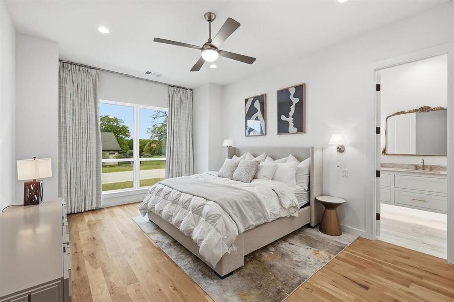 Bedroom featuring light wood-type flooring, ceiling fan, recessed lighting, and ensuite bath