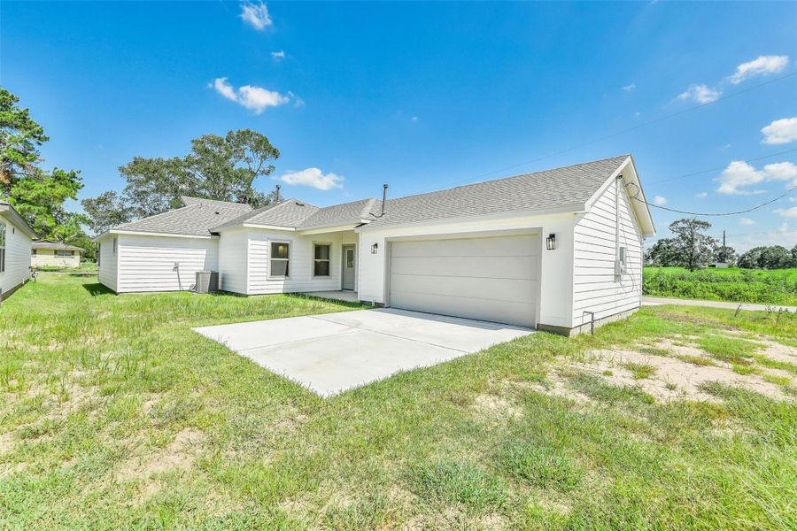 Spacious backyard with a covered patio and direct access to the attached garage, offering a blank slate to create your ideal outdoor space.