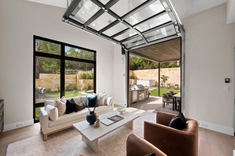 Seamless indoor-outdoor flow redefined. A glass garage door retracts to completely open the game room to the back patio