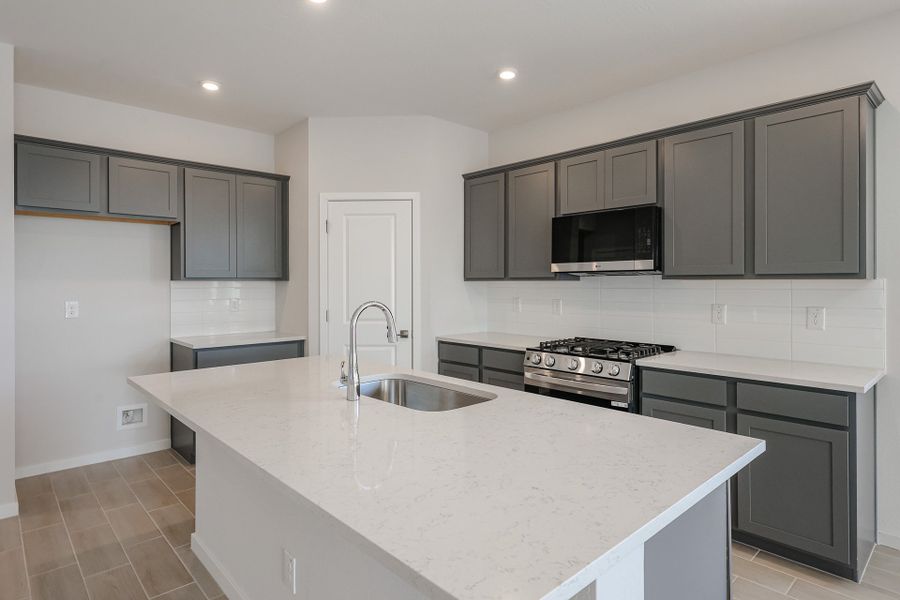 A kitchen with black cabinets.