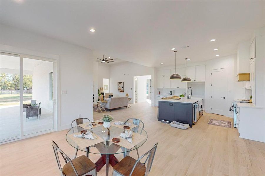 Dining room with ceiling fan and light wood-type flooring