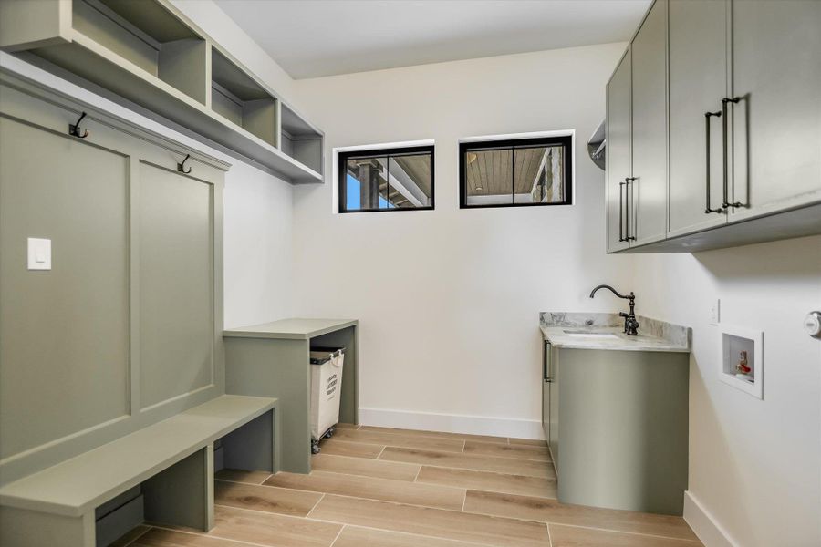 Utility room featuring wood-finish flooring and light-toned walls
