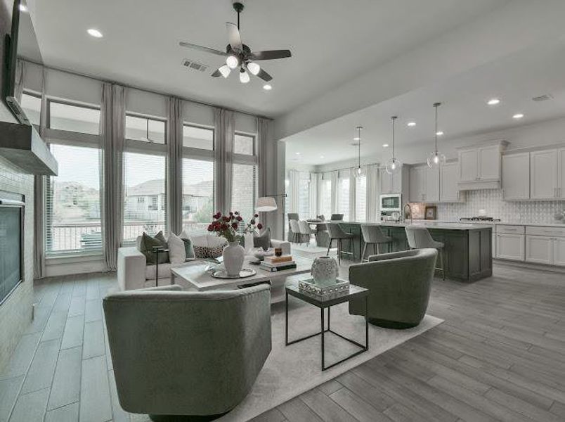 Living room with light wood-style flooring, recessed lighting, a ceiling fan, and a glass covered fireplace Living room with light wood-style flooring, recessed lighting, a ceiling fan, and a glass covered fireplace