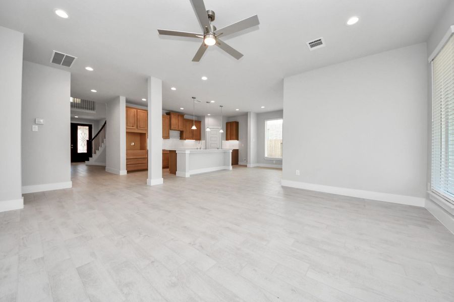 Gather the family and guests together in your lovely living room! Featuring soaring high ceilings, recessed lighting, ceiling fan, custom paint, gorgeous floors, and large windows that provide plenty of natural lighting throughout the day. Sample photo of completed home with similar floor plan. Actual colors and selections may vary. Gather the family and guests together in your lovely living room! Featuring soaring high ceilings, recessed lighting, ceiling fan, custom paint, gorgeous floors, and large windows that provide plenty of natural lighting throughout the day. Sample photo of completed home with similar floor plan. Actual colors and selections may vary.