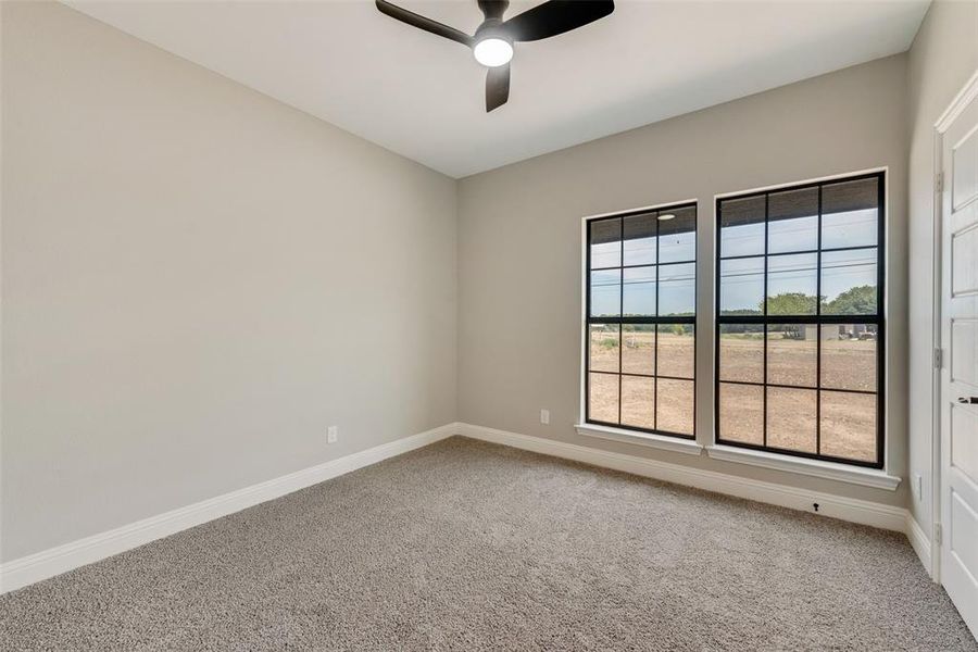 Carpeted empty room with ceiling fan