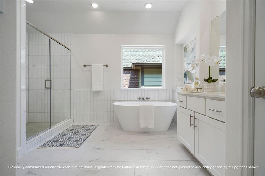 Ensuite Elegance: Step into the primary suite's ensuite bathroom, boasting abundant space and luxurious finishes, including a spa-like shower adjacent to the elegant freestanding tub.