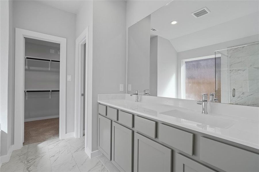 This primary bathroom is definitely move-in ready! Featuring stained cabinets with light countertops, spacious walk-in closet with shelving, high ceilings, custom paint, sleek and dark modern finishes.