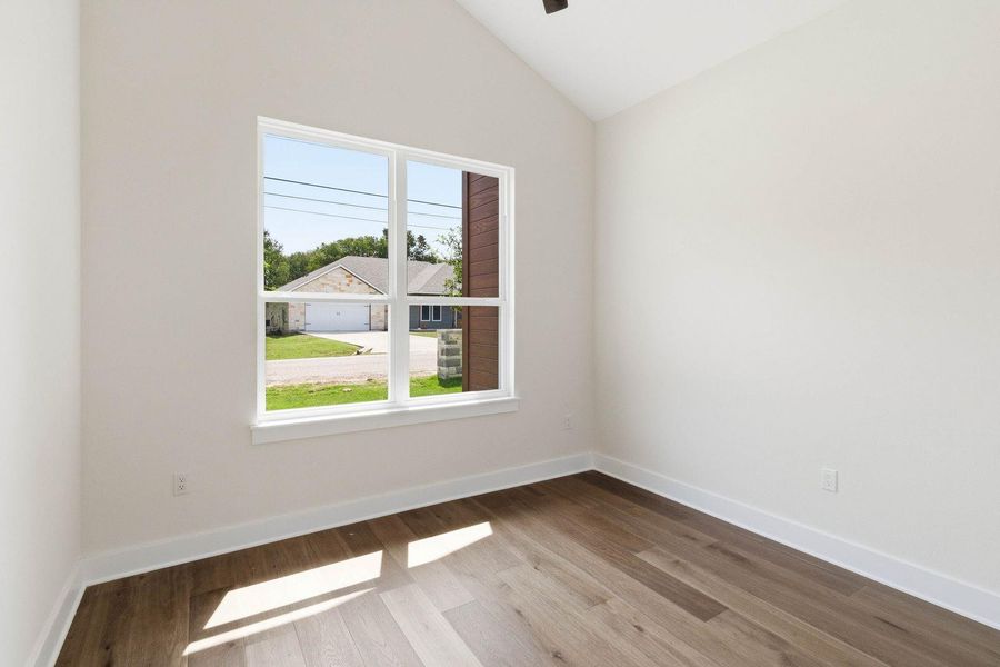 An airy room offers vaulted ceilings and wood flooring, perfect for a versatile space. An airy room offers vaulted ceilings and wood flooring, perfect for a versatile space.